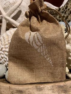 a burlocked bag sitting on top of a wooden table next to seashells