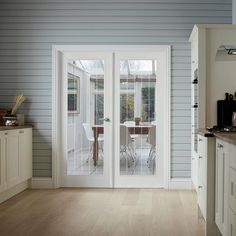 an open door leading to a dining room and kitchen