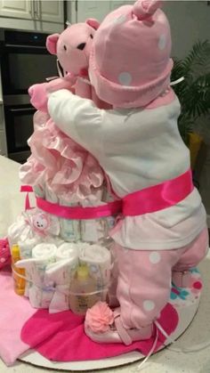 a large pink teddy bear sitting on top of a pile of diapers