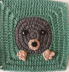 a crocheted square with a teddy bear on it's face and paws