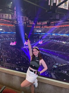 a woman is posing in front of an arena