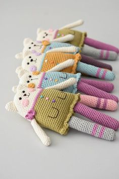 small knitted animal finger puppets lined up on a white surface with one stuffed animal in the middle