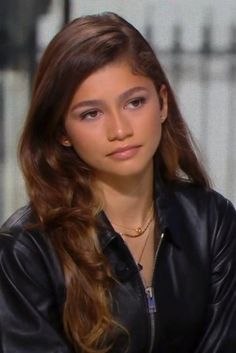 a woman with long hair wearing a black leather jacket