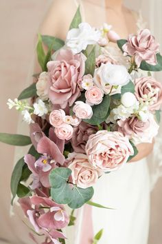 a bride holding a bouquet of pink and white flowers