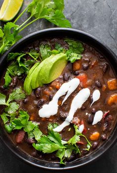 a black bowl filled with chili and beans