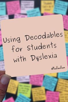 a hand holding up a sticky note with the words using decoables for students with dyslexiia