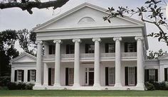 an old white house with columns on the front