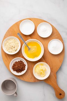 the ingredients to make an easy chocolate cake are arranged in bowls on a wooden platter