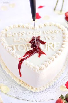 a heart shaped cake is being cut with a knife