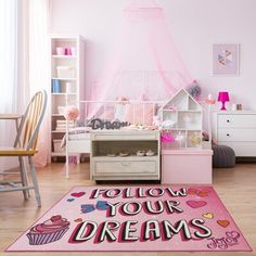 a bedroom with pink walls and flooring has a rug that says follow your dreams