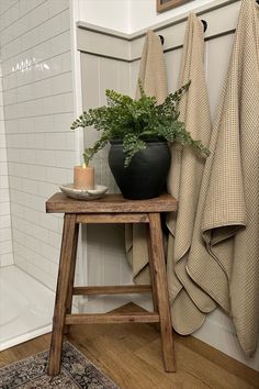 a wooden table with towels and a potted plant on it