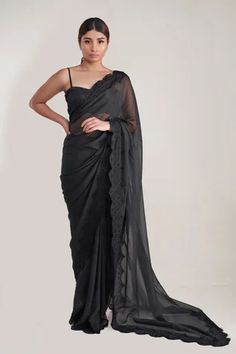 Black saree in a pure silk organza base with tonal chantilly lace trim on the border. Comes with strappy black blouse
Component: 2
Neckline: Sweetheart
Sleeve Type: Sleeveless
Fabric: Organza
Color: Black
Other Details: 
Chantilly lace border saree
Blouse with shoulder straps
Closure: Back hook
Occasion: Sangeet - Aza Fashions Sarees Black, Lace Border Saree, Party Saree, Saree Work, Kundan Work, Kalki Fashion, Party Sarees, Border Saree, Drape Saree