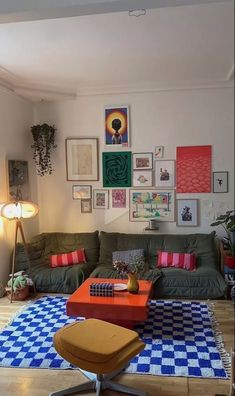 a living room filled with lots of furniture and pictures on the wall above it's coffee table