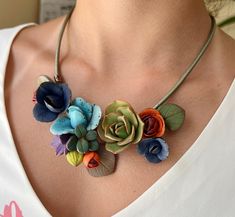 a woman wearing a necklace with flowers on it