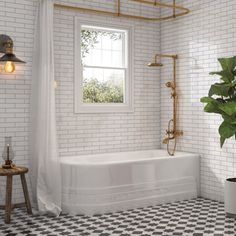 a bathroom with black and white checkered flooring, a potted plant on the side of the bathtub