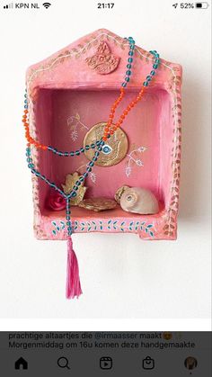 a pink box with beads and other items in it on a white wall next to an instagram post