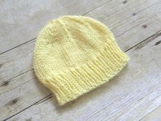 a yellow knitted hat sitting on top of a wooden floor