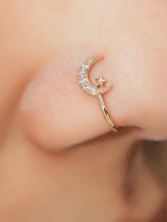 a close up of a person's nose with a crescent shaped ring on it