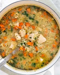 a bowl of chicken and rice soup with a ladle on the side, ready to be eaten