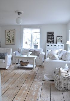 a living room filled with white furniture and lots of windows