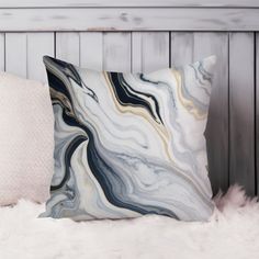 two pillows sitting on top of a white fur covered bed