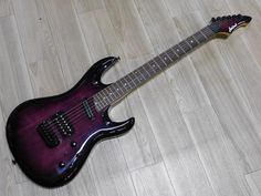 a purple electric guitar laying on the floor