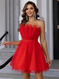 a woman in a red dress posing for the camera with her hand on her hip