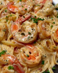 pasta with shrimp and sauce on it sitting on a plate