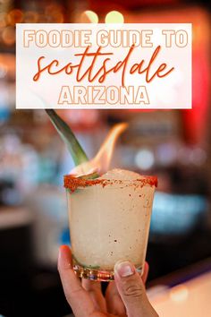 a person holding up a drink with the words foodie guide to scottsdale arizona