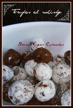 a bowl filled with chocolate covered donuts on top of a table