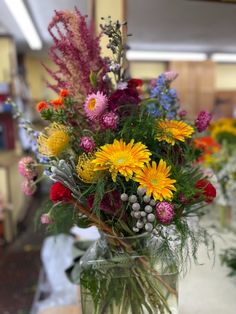 a vase filled with lots of different colored flowers