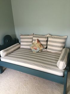 a bed with striped sheets and pillows on it