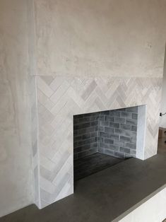 a fireplace with white and gray tile on the mantle