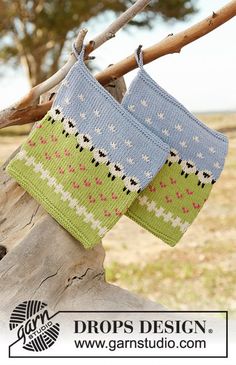 two knitted bags hanging from a tree branch