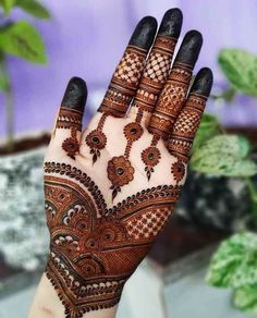 the hand is decorated with henna designs on it's fingers and palm area