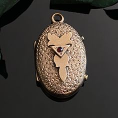 "Antique Victorian rose gold filled garnet oval locket with textured front and embossed floral design on back. Includes original frames but does not have glass. Good condition with typical signs of age including some metal on back. Measures 0.9\" x 0.55\" not including bail loop." Victorian Rose Gold Locket Necklace, Vintage Rose Gold Oval Locket Necklace, Victorian Oval Locket Necklace With Vintage Charm, Oval Victorian Locket Necklace With Vintage Charm, Ornate Oval Locket Necklace For Formal Occasions, Vintage Oval Locket Necklace Collectible, Antique Rose Gold Locket Necklace, Ornate Oval Locket Necklace From Vintage Collection, Vintage Oval Locket Necklace For Anniversary