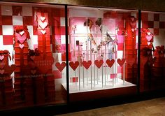 a display case with red and white hearts on it's glass doors, in front of a store window