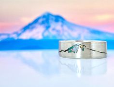 a close up of a ring on a table with a mountain in the back ground