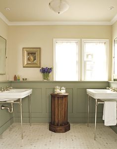 a bathroom with two sinks and a pedestal in the middle of the bathtub area