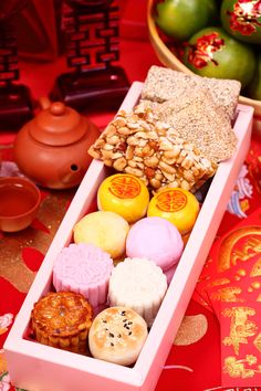 a box filled with lots of different types of food on top of a red table cloth