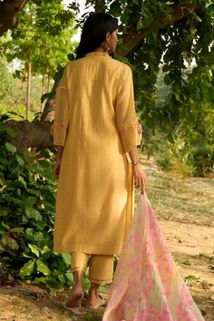 Yellow kurta with intricate smocking details, floral printed tie-up on sleeves and frill edged neckline. Comes with floral printed dupatta and embroidered hem pant. - Aza Fashions Traditional Handloom Kurta For Spring, Traditional Spring Sets With Back Tassel Tie-up, Traditional Cotton Kurta With Back Tassel Tie-up, Traditional Summer Sets With Back Tassel Tie-up, Festive Spring Kurta With Back Tassel Tie-up, Traditional Sets With Yoke For Spring, Traditional Spring Set With Yoke Detail, Yellow Kurta, Embroidered Hem