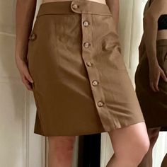 Awesome Skirt For The Office, Class, Vacation, Or A Casual Hike It Has Pockets! Kind Of A Dark Camel /Cafe Au Lait Sort Of Color The Pictures Where Model Is Wearing Are Truest To Color. Faux Tortoiseshell Buttons Complement The Tan Color Size Xs Shown On 6/8 5’8” 34”-29”-37”Runs A Bit Big Never Worn, New With Tags Including The Spare Bag O Buttons Viscose Rayon / Nylon / Spandex Blend Pencil Skirt A Line Professional Job Interview Academia Bougie Old Money Look Aesthetic Sporty Coastal Chic Vani Fitted Buttoned Skort In Short Length, Fitted Short Length Skort With Buttons, Fitted Cargo Skirt With Button Closure, Solid Color Skirt With Button Closure, Solid Skirt With Button Closure, Fitted Mini Skirt With Snap Buttons, Workwear Mini Skirt With Side Buttons, Brown Mini Skirt With Button Closure For Work, Casual Brown Skirt With Buttons