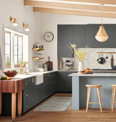 a kitchen with grey cabinets and wooden stools