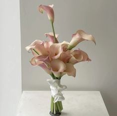 a vase filled with pink flowers on top of a table