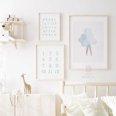 a bedroom with white walls and pictures on the wall, including a baby's crib