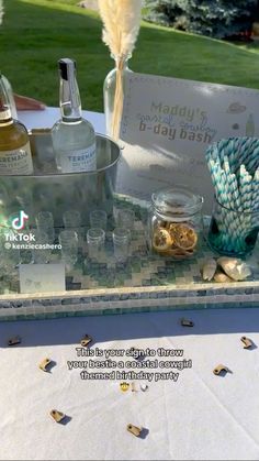 an outdoor bar set up with liquor bottles and other items on the table in front of it