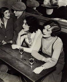 four women sitting at a table with wine glasses