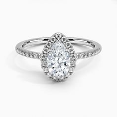 a pear shaped diamond engagement ring on a white background