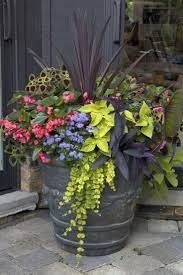 a large potted planter filled with flowers sitting on the side of a building