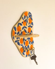 an orange and blue wall hanging with a key